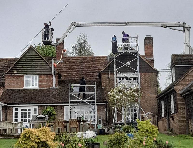 The Roof Moss Cleaners using cherry picker and scaffolding to clean roof safely and professionally in Steyning, West Sussex